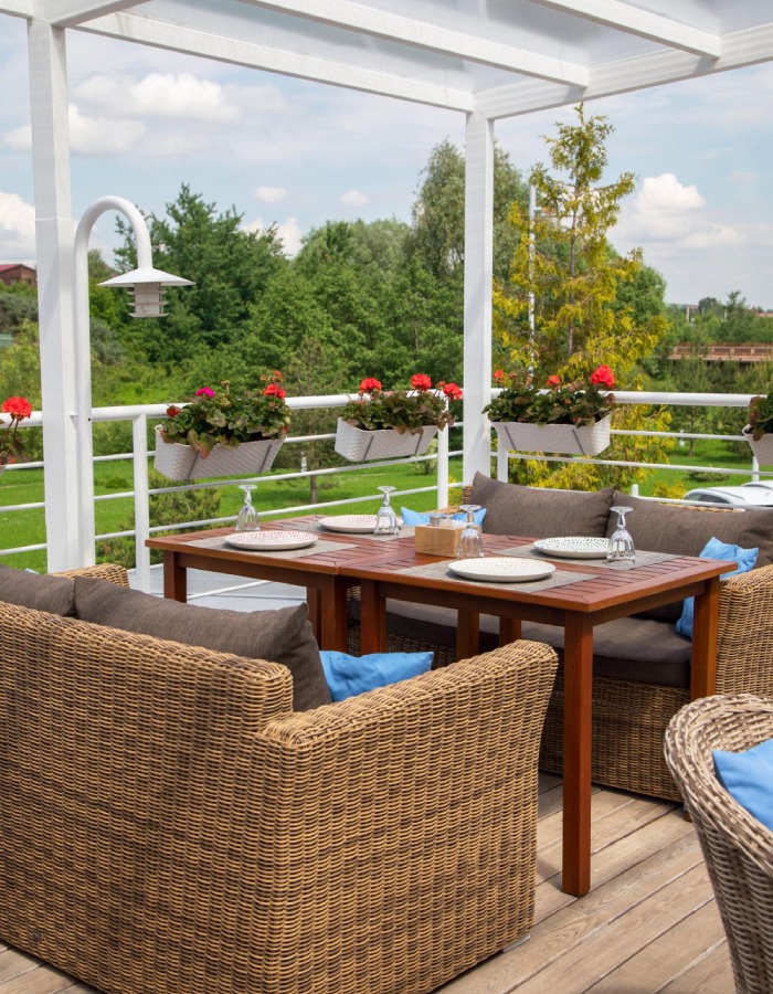 Terrasse contemporaine avec pergola blanche et mobilier tressé – L’Ère du Bois