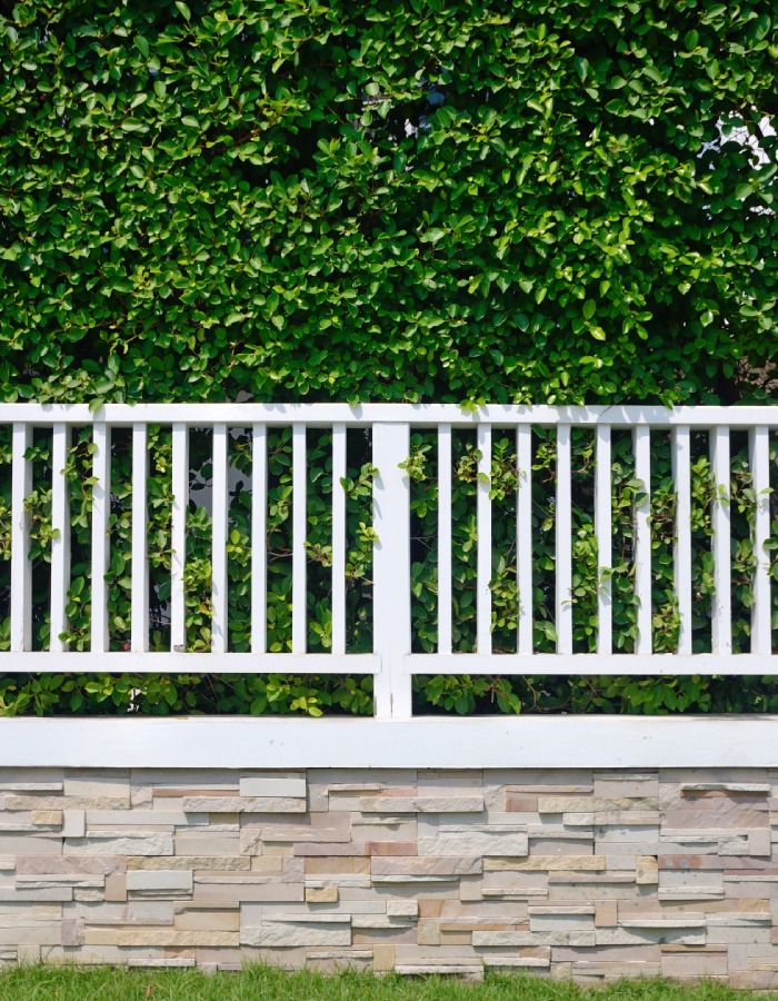 Clôture blanche en bois sur muret de pierre – L’Ère du Bois